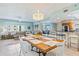 Open-concept dining area with stylish chandelier next to the living room and kitchen at 5300 S Atlantic Ave # 12-401, New Smyrna Beach, FL 32169