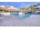 Community pool with tiled deck, lounge chairs, and beautiful landscaping at 5300 S Atlantic Ave # 12-401, New Smyrna Beach, FL 32169