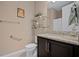 Bathroom vanity with granite countertop, sleek dark cabinets, and clear glass shelving at 5648 Nw 40Th Loop, Ocala, FL 34482