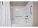 Bright bathroom with white tiled walls, a tub, and chrome fixtures at 5648 Nw 40Th Loop, Ocala, FL 34482