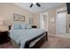 Bedroom with ensuite bath, features carpet, fan, and bright window at 5648 Nw 40Th Loop, Ocala, FL 34482