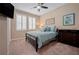 Comfortable bedroom featuring neutral walls, plush carpet, ceiling fan, and a nicely framed window at 5648 Nw 40Th Loop, Ocala, FL 34482