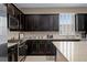 Close-up view of a modern kitchen with stainless steel appliances, granite countertops, and dark cabinetry at 5648 Nw 40Th Loop, Ocala, FL 34482