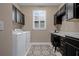 Laundry room includes front load washer, dryer, custom cabinets, utility sink, and window at 5648 Nw 40Th Loop, Ocala, FL 34482