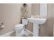 Powder room features a pedestal sink, toilet and open shelving at 5648 Nw 40Th Loop, Ocala, FL 34482