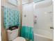 Stylish bathroom featuring a shower-tub combo with a decorated curtain, toilet, and teal-themed towels at 565 Morgan Wood Dr, Deland, FL 32724