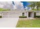 Inviting single-story home with a manicured lawn, tidy landscaping, and a spacious two-car driveway at 565 Morgan Wood Dr, Deland, FL 32724