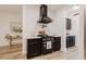 Modern kitchen featuring dark cabinetry, a sleek range hood, and herringbone backsplash at 565 Morgan Wood Dr, Deland, FL 32724
