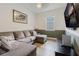 Cozy living room with sectional sofa, mounted TV, and neutral decor at 565 Morgan Wood Dr, Deland, FL 32724