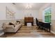 Bright living room featuring wood floors, neutral paint, a piano, sofa, desk and sunlit window at 565 Morgan Wood Dr, Deland, FL 32724