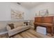 Bright living room featuring wood floors, neutral paint, a piano, sofa, and modern decor at 565 Morgan Wood Dr, Deland, FL 32724