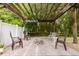 Inviting patio with brick pavers, pergola, string lights, and a cozy brick fire pit, perfect for outdoor relaxation and entertainment at 565 Morgan Wood Dr, Deland, FL 32724