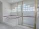 This bathroom features a glass-enclosed shower, a tub, white tile, and neutral accents for a luxurious feel at 5936 Boggs Ford Rd, Port Orange, FL 32127
