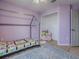 This stylish ' bedroom is painted purple and includes a closet and house frame bed at 5936 Boggs Ford Rd, Port Orange, FL 32127