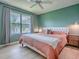 Comfortable bedroom with natural light, featuring a ceiling fan and a view of the surrounding greenery at 5936 Boggs Ford Rd, Port Orange, FL 32127