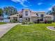 Charming two-story home with manicured lawn, brick accents, and a welcoming front entrance under a bright blue sky at 5936 Boggs Ford Rd, Port Orange, FL 32127