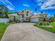 Well-maintained two-story home featuring a spacious driveway leading to an attached garage, under a vibrant blue sky at 5936 Boggs Ford Rd, Port Orange, FL 32127