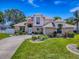 Charming two-story home boasts a manicured lawn, mature landscaping, and an inviting entrance with brick accents at 5936 Boggs Ford Rd, Port Orange, FL 32127
