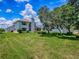 Lush backyard showcasing a well-maintained lawn, mature trees, and a view of the home's exterior, perfect for outdoor enjoyment at 5936 Boggs Ford Rd, Port Orange, FL 32127