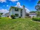 Well-manicured lawn and exterior of the home showcase a landscaped yard, mature trees, and a spacious backyard, ideal for outdoor activities at 5936 Boggs Ford Rd, Port Orange, FL 32127