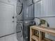Modern, stacked washer and dryer set in the laundry room with a shelving unit to the side at 5936 Boggs Ford Rd, Port Orange, FL 32127