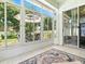 Bright sunroom featuring large windows with views of the landscaped yard, and tiled flooring at 5936 Boggs Ford Rd, Port Orange, FL 32127