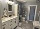 Well-lit bathroom featuring a double sink vanity with black hardware, a toilet, and a storage cabinet at 6211 Oak River Ter, Port Orange, FL 32127