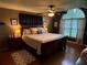 Comfortable bedroom featuring a ceiling fan, dark wood furniture, and a large window at 6211 Oak River Ter, Port Orange, FL 32127