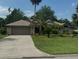 Charming brick home featuring a well-manicured lawn and mature palm trees at 6211 Oak River Ter, Port Orange, FL 32127