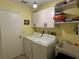 A brightly lit laundry room with white cabinets, a washer, and a dryer at 6211 Oak River Ter, Port Orange, FL 32127