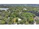 An aerial view of a property surrounded by mature trees and landscaping near a lake and adjacent neighborhood at 626 Cannon St, Daytona Beach, FL 32114