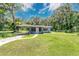 Quaint home featuring lush green lawn and mature trees, providing a private and inviting outdoor space at 626 Cannon St, Daytona Beach, FL 32114