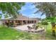 Landscaped backyard featuring an outdoor fire pit and covered patio space at 202 Yorkville Pl, Debary, FL 32713