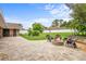 Backyard with a stone fire pit and chairs, surrounded by a lush green lawn and landscaped gardens, perfect for relaxing evenings at 202 Yorkville Pl, Debary, FL 32713