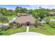 Beautiful exterior elevation with manicured lawn, mature trees, and stone accents creating a welcoming curb appeal at 202 Yorkville Pl, Debary, FL 32713