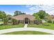 Beautiful brick home featuring a circular driveway and well-manicured landscaping at 202 Yorkville Pl, Debary, FL 32713