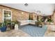 Inviting outdoor patio with comfortable wicker seating, a patterned rug, and lush greenery, perfect for relaxing and entertaining at 202 Yorkville Pl, Debary, FL 32713