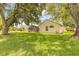 Lovely backyard with lush green grass, mature trees, and a screened-in porch at 212 Mallard Ln, Daytona Beach, FL 32119