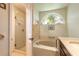 Bathroom showcasing glass enclosed shower and a soaking tub with grab bars at 212 Mallard Ln, Daytona Beach, FL 32119