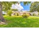 Beautiful home exterior showcasing lush green lawn, mature landscaping, and a sunny sky at 212 Mallard Ln, Daytona Beach, FL 32119