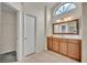 Bathroom features a wood vanity with a decorative mirror and tiled floors, filled with natural light at 2237 Clearwater Dr, Deltona, FL 32738