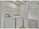 Laundry room with washer, dryer, and storage shelving that opens to an adjacent bedroom at 2237 Clearwater Dr, Deltona, FL 32738