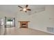 Cozy living room with tiled floors, a brick fireplace, and a ceiling fan, creating a warm and inviting atmosphere at 2237 Clearwater Dr, Deltona, FL 32738