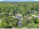 Beautiful aerial view of a property with mature trees surrounding the home and a serene backyard pond at 28432 Tammi Dr, Tavares, FL 32778