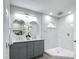 Beautiful bathroom featuring a double sink vanity, round mirrors, and a luxurious glass enclosed shower at 28432 Tammi Dr, Tavares, FL 32778