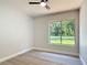 Bright, neutral bedroom with a large window showcasing a peaceful outdoor view at 28432 Tammi Dr, Tavares, FL 32778
