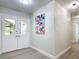 Bright entryway boasts double glass paneled doors, modern art, and a view into the living spaces at 28432 Tammi Dr, Tavares, FL 32778