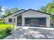 Charming home featuring a two-car garage with modern doors, situated on a lush, green lot at 28432 Tammi Dr, Tavares, FL 32778