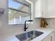 Kitchen sink with modern faucet, quartz countertop, and view of backyard, combining style and functionality at 28432 Tammi Dr, Tavares, FL 32778