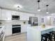 Modern kitchen featuring stainless steel appliances, white cabinets, and a central island with barstool seating at 28432 Tammi Dr, Tavares, FL 32778